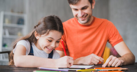 Un père et sa fille complètent ensemble le cahier de jeux sur le développement durable