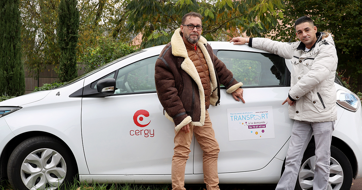 Deux chauffeurs du service de transport à la demande de la ville de Cergy posent côte à côte.