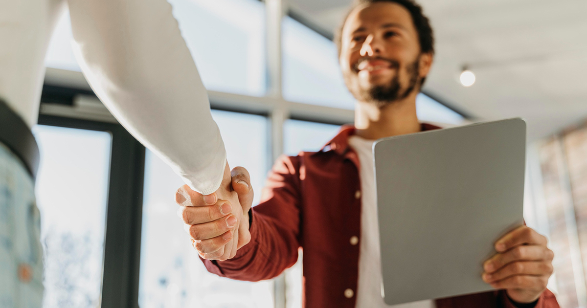 Un homme serre la main d’une autre personne en signe d’accompagnement